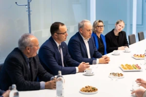 two women and three men sitting at the table in an official meeting